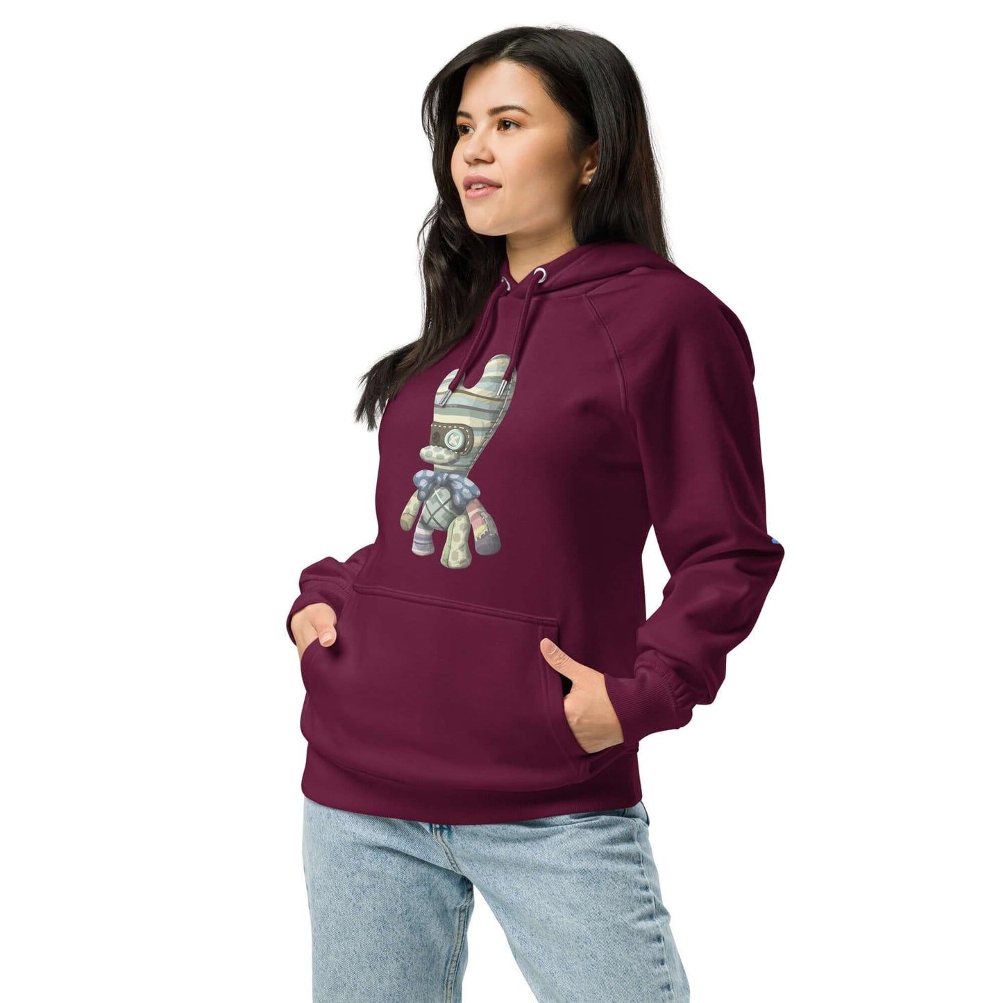 Model wearing Unisex Bio-Raglan-Hoodie in burgundy with a stylish graphic design, paired with casual jeans.
