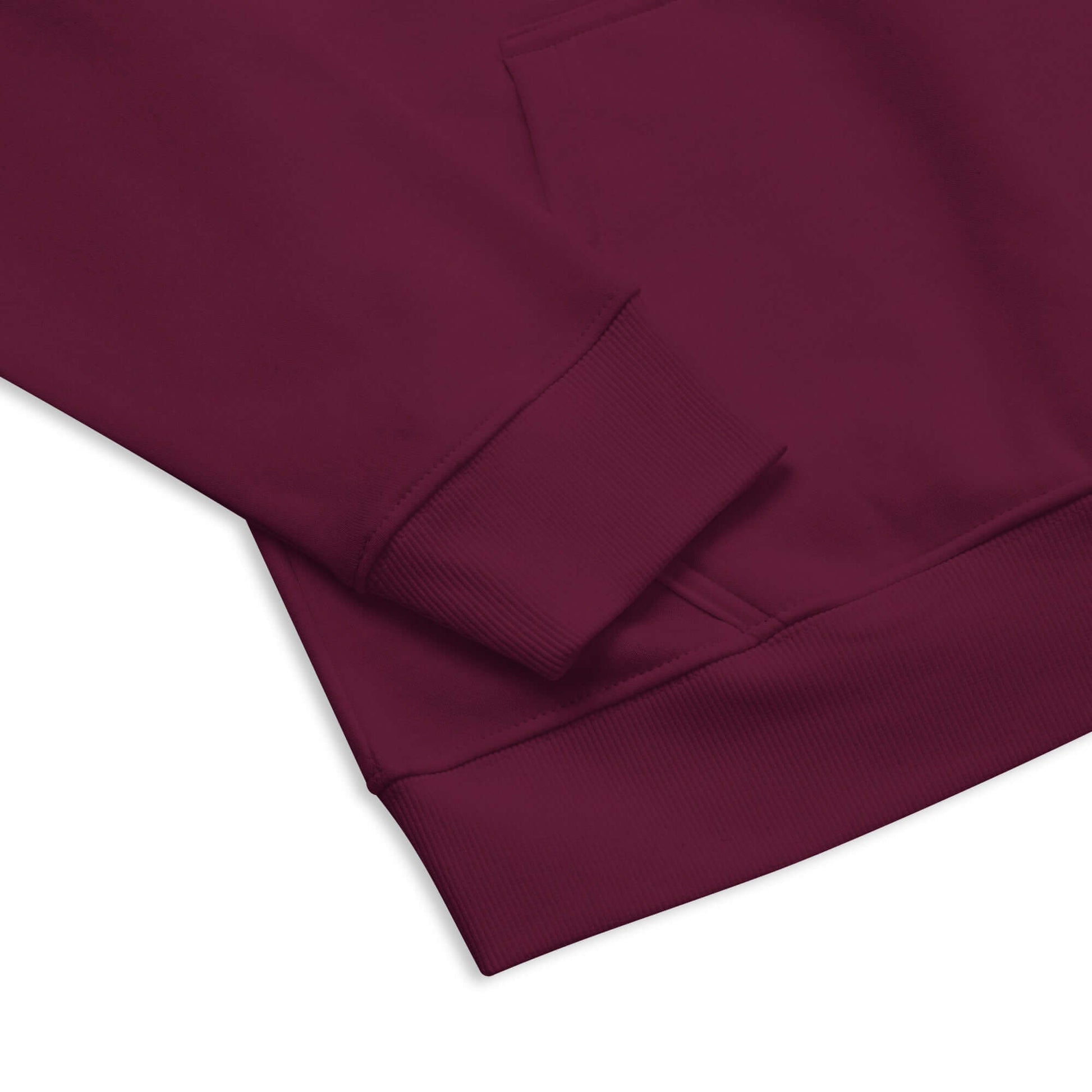 Close-up of sleeve and hem of a maroon Unisex Bio-Raglan-Hoodie, featuring soft fabric and detailed stitching for comfort and style.