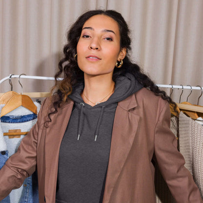Woman wearing Unisex Bio-Raglan-Hoodie with a blazer, showcasing fashion versatility and comfort.