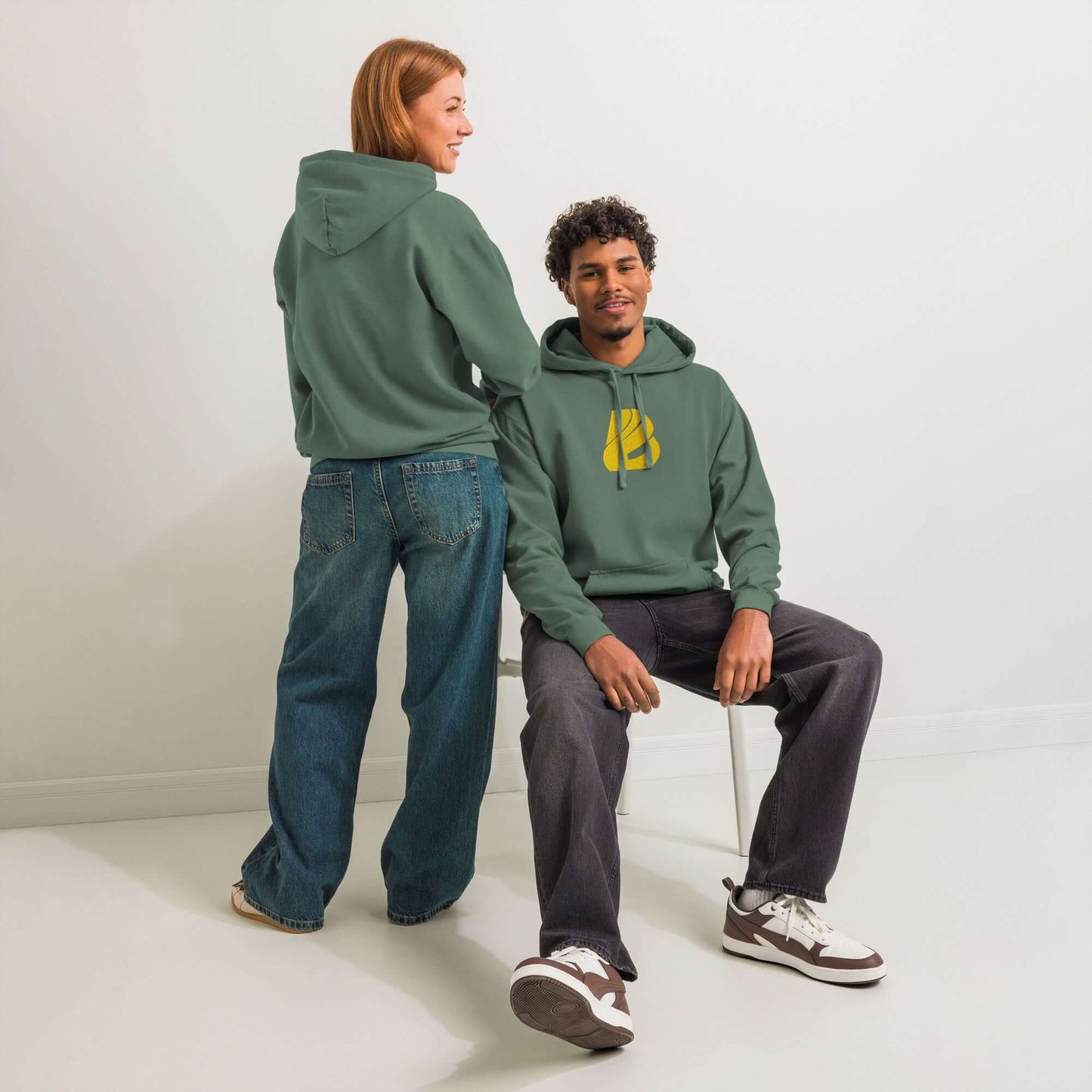 Zwei Personen tragen textilgefärbten Unisex-Hoodie in grüner Farbe, gemütliches Design ideal für Alltag und Entspannung.