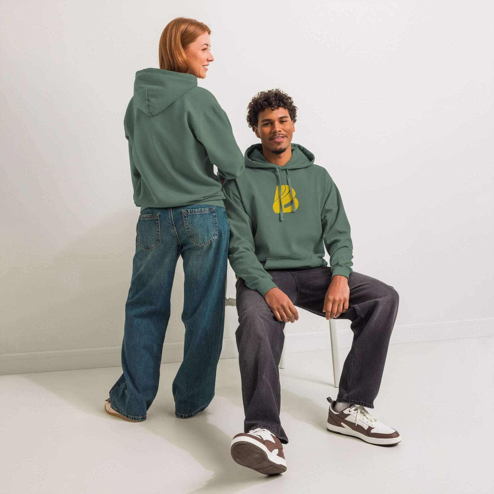 Zwei Personen tragen textilgefärbten Unisex-Hoodie in grüner Farbe, gemütliches Design ideal für Alltag und Entspannung.