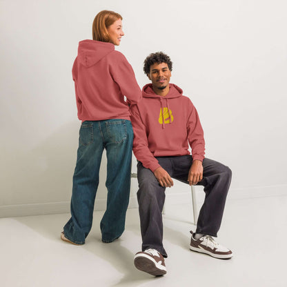 Man and woman wearing Textilgefärbter Unisex-Hoodie in casual setting, showcasing soft cotton blend and relaxed fit.