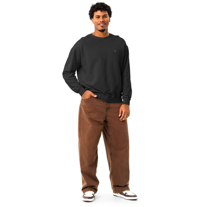 Leichter textilgefärbter Unisex-Fleece-Pullover mit Rundhalsausschnitt in Schwarz, lässig mit braunen Hosen getragen von Model.