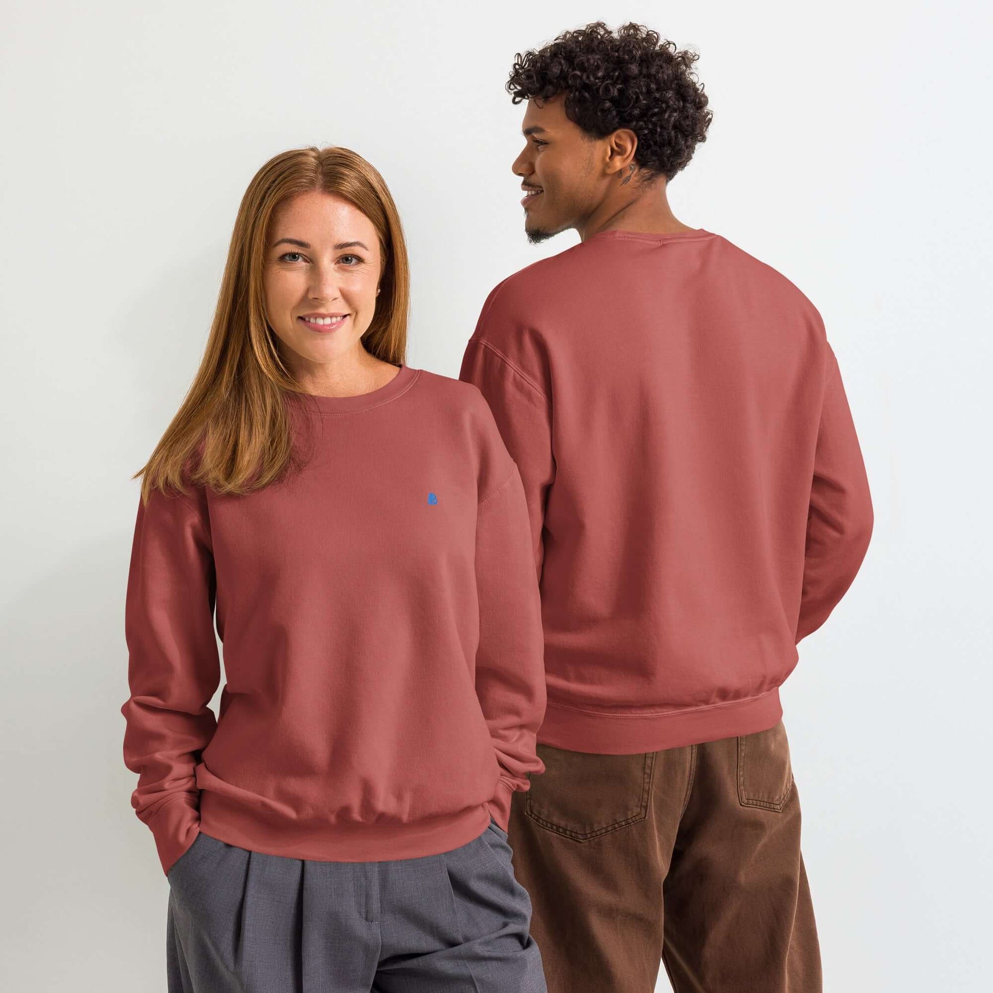 Leichter textilgefärbter Unisex-Fleece-Pullover mit Rundhalsausschnitt in terrakotta getragen von einem Paar, zeigt vorderen und hinteren Stil.