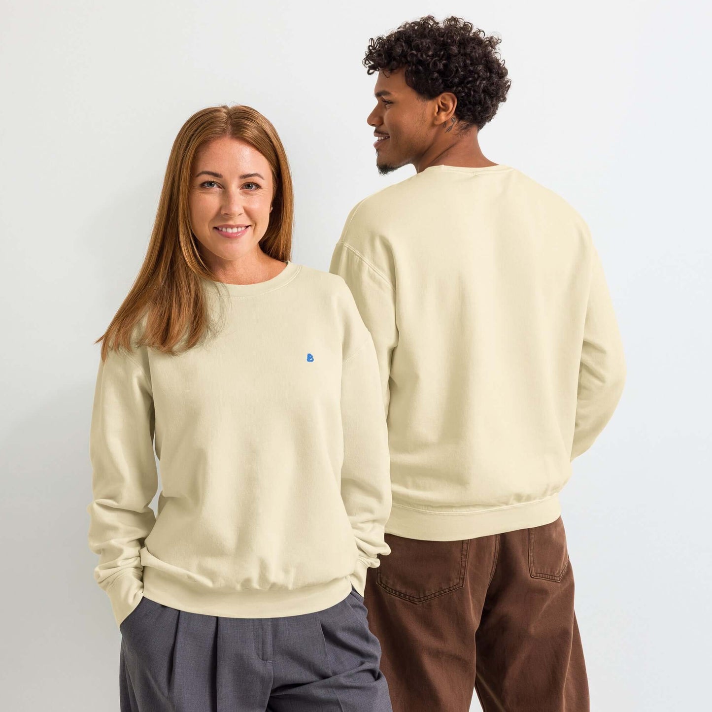 Leichter textilgefärbter Unisex-Fleece-Pullover mit Rundhalsausschnitt in hellem Beige, getragen von einem Mann und einer Frau.