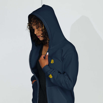 Woman wearing Unisex Heavy-Blend Zip Hoodie N°0 with hood up, navy color, showing front zip and pocket details in soft fleece.