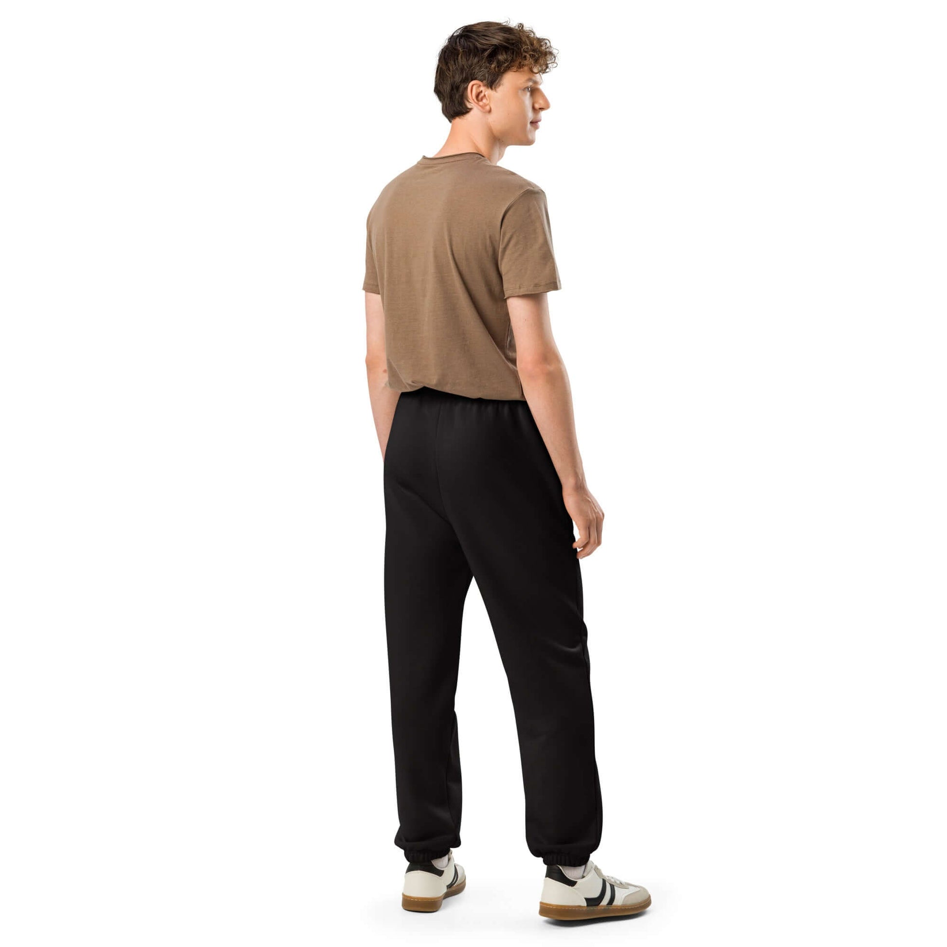 Person wearing schwarze Schwere Jogginghose in 90er-Stil mit elastischen Bündchen und tiefen Taschen, streetwear look.