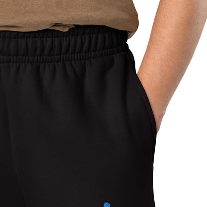Close-up of a person wearing schwarze schwere Jogginghose with deep side pockets and elastic waistband.