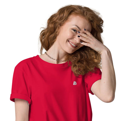 Smiling woman wearing red Unisex-Bio-Baumwoll-T-Shirt N°2, showcasing sustainable fashion.