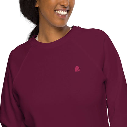 Woman wearing Unisex Bio-Raglan-Pullover N°3 in maroon, stylish and comfortable cotton fleece sweatshirt.