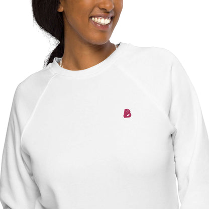 Person wearing white Unisex Bio-Raglan-Pullover N°3 with small logo, showcasing stylish comfort and soft organic cotton material.