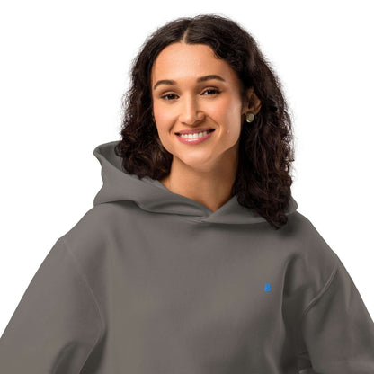 Woman wearing Schwerer Oversized Hoodie with a smile, showcasing the comfortable fit and soft fabric. Ideal for lounging and relaxation.