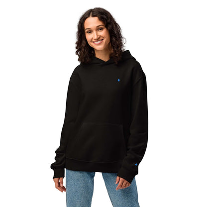 Woman wearing black Schwerer Oversized Hoodie with no drawstrings, featuring breathable cotton-polyester fleece.