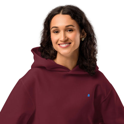 Woman wearing burgundy Schwerer Oversized Hoodie with comfy fleece and breathable cotton blend, perfect for lounging.