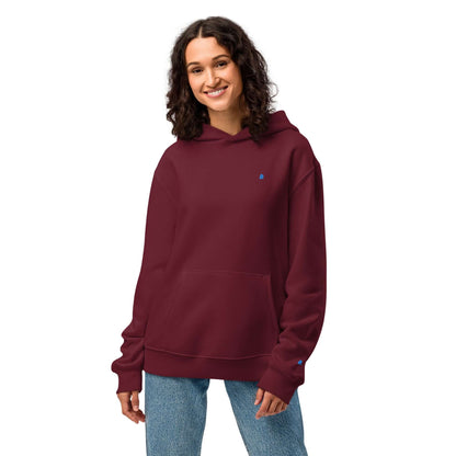Woman wearing a burgundy Schwerer Oversized Hoodie, showcasing its relaxed fit and cozy fabric for comfort and style.