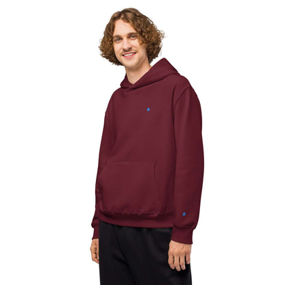 Model wearing Schwerer Oversized Hoodie in maroon with comfortable fit for lounging, made from breathable cotton-polyester fleece.