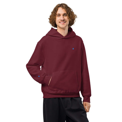 Schwerer Oversized Hoodie in burgundy red worn by person, featuring brushed fleece and spacious fit for comfort.