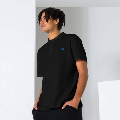Person wearing black Unisex Piqué-Poloshirt N°0 in stylish setting