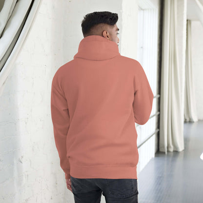 Man wearing Unisex-Kapuzenpullover N°49 in coral pink, showcasing back design with hood in a modern indoor setting.