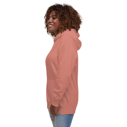 Side view of smiling person wearing Unisex-Kapuzenpullover N°49 in coral, featuring a warm hood and front pouch pocket.