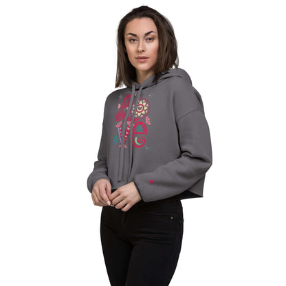 Frau trägt grauen Crop-Hoodie mit offenem Saum und buntem Aufdruck, modischer Look für die Garderobe.