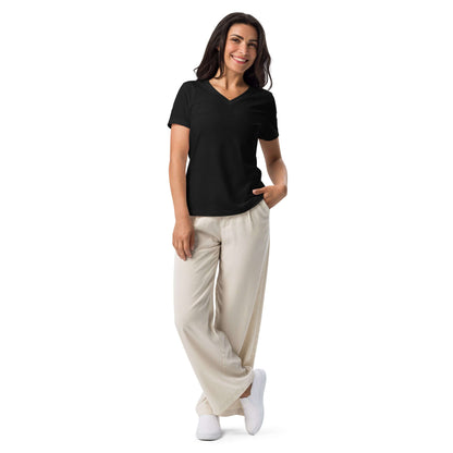 Frau trägt Lockeres Damen T-Shirt mit V-Ausschnitt N°1 in Schwarz, kombiniert mit beigen Hosen, stilvoller Alltagslook.