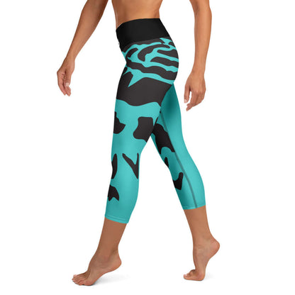 Yoga-Capri-Leggings mit hohem Bund und türkis-schwarzem Muster, ideal für Fitness und Freizeit, vorgeführt von einer Frau in Bewegung.