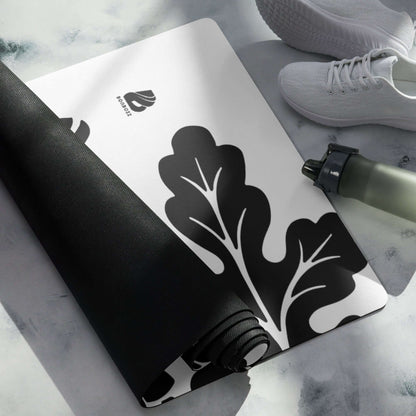 Yoga-Matte N°0 with black and white design, rolled on a marble surface; perfect for exercise, stretching, and meditation.