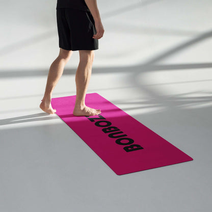 Person stepping on Yoga-Matte N°1, a pink yoga mat with non-slip rubber underside and soft microsuede top, perfect for exercise.