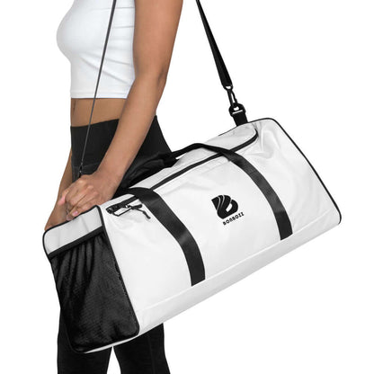 Person carrying a white Weekender N°5 duffel bag with adjustable shoulder strap.