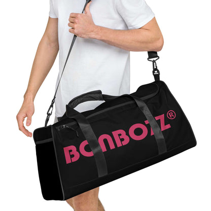 Person carrying Weekender N°22 bag in black with pink logo, versatile for travel, daily errands, or gym with adjustable shoulder straps.