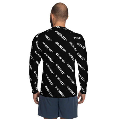 Man wearing Herren-Rash-Guard N°25 with ergonomic seams and black design, protecting from sun and sand. Made of polyester and elastane.