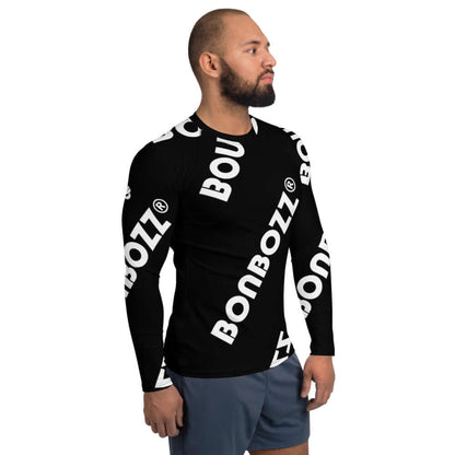 Mann trägt Herren-Rash-Guard N°10 für Sport und Sonnenschutz, langer Ärmel, schwarzes Design mit weißen Logos.