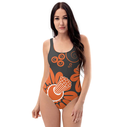 Einteiliger Badeanzug N°16 mit floralem Design im Vordergrund, getragen von einer Frau, ideal für Strand und Pool.