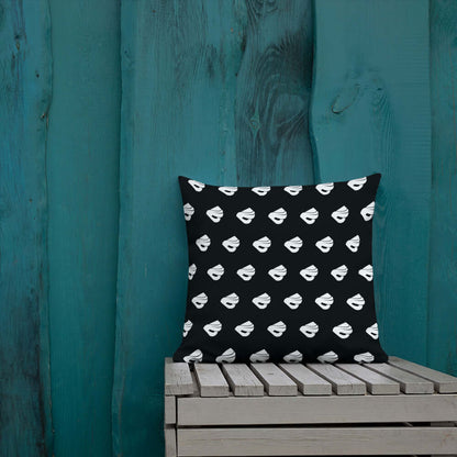 Premium-Kissen N°0 on wooden bench against teal wall, black cover with white pattern.