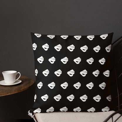 Premium-Kissen N°0 with black and white pattern on a chair next to a coffee cup, perfect for adding luxury and comfort to any room.