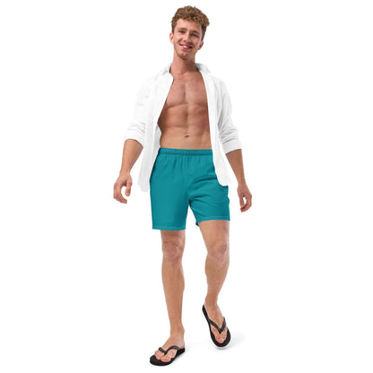 Model wearing Herren-Badehosen N°10 in turquoise with open white shirt, features quick-dry, breathable fabric and pockets.