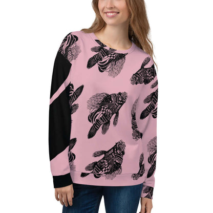 Woman wearing Unisex-Pullover N°12 with intricate fish design on pink fabric, featuring a comfortable fit and soft fleece material.