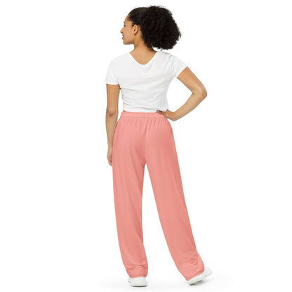 Back view of person wearing Unisex-Hose mit weiten Beinen und Allover-Druck N°0 in pink, showcasing elastic waistband and loose fit.