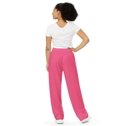 Model wearing Unisex-Hose mit weiten Beinen und Allover-Druck N°2, pink wide-leg pants with adjustable waist and white drawstring.