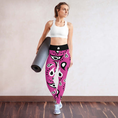 Woman wearing Yoga-Leggings N°18 with pink abstract design, holding a yoga mat, showcasing comfort and stretch flexibility.
