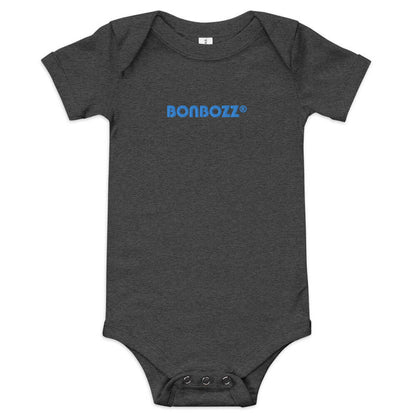 Kurzärmliger Baby-Einteiler N°0 aus 100% Baumwolle in dunkelgrau mit blauem Print, komfortabler Schnitt, Druckknopfverschlüsse.