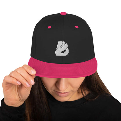 Person wearing Snapback-Cap N°1 with black and pink design, featuring embroidered logo on front. Ideal for trendy, adjustable headwear.