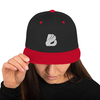 Snapback-Cap N°1 in black and red worn by a model, featuring structured 6-panel design, flat brim, and adjustable snap closure.