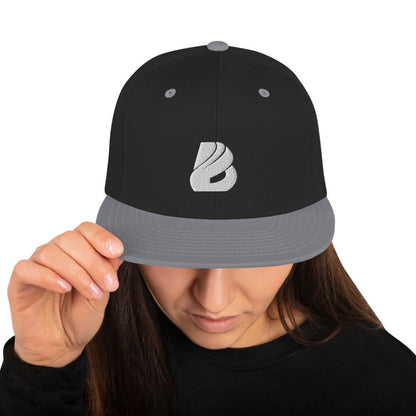 Person wearing Snapback-Cap N°1 with a black and gray design, showing front view.