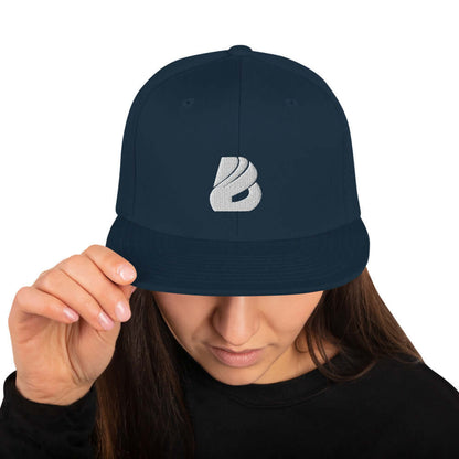 Person wearing a Snapback-Cap N°1 with classic fit, structured high-profile, and curved brim, featuring adjustable plastic snap closure in navy.
