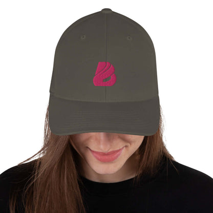 Person wearing Strukturierte Cord-Cap N°0, elastic stretch-band, mid-profile, in dark color with pink logo.