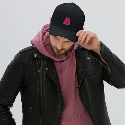 Man wearing Strukturierte Cord-Cap N°0, black with pink logo, showing athletic shape and curved visor, paired with a leather jacket and hoodie.