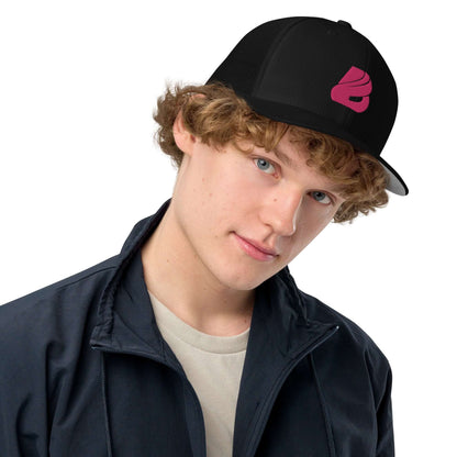 Person wearing black Trucker-Cap mit geschlossener Rückseite N°0 with pink logo, styled with casual jacket.