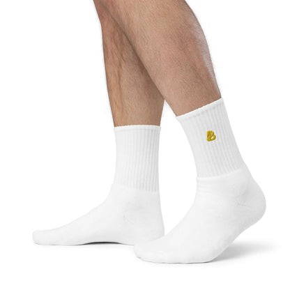 Person wearing white Bestickte Socken N°0 with gold embroidery, showcasing quality comfort and style.